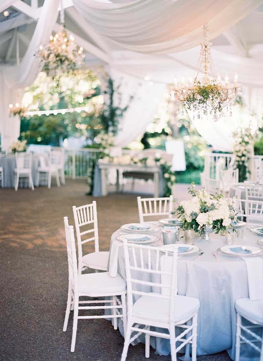 blue grey and white wedding reception with flowers in outdoor pavilion