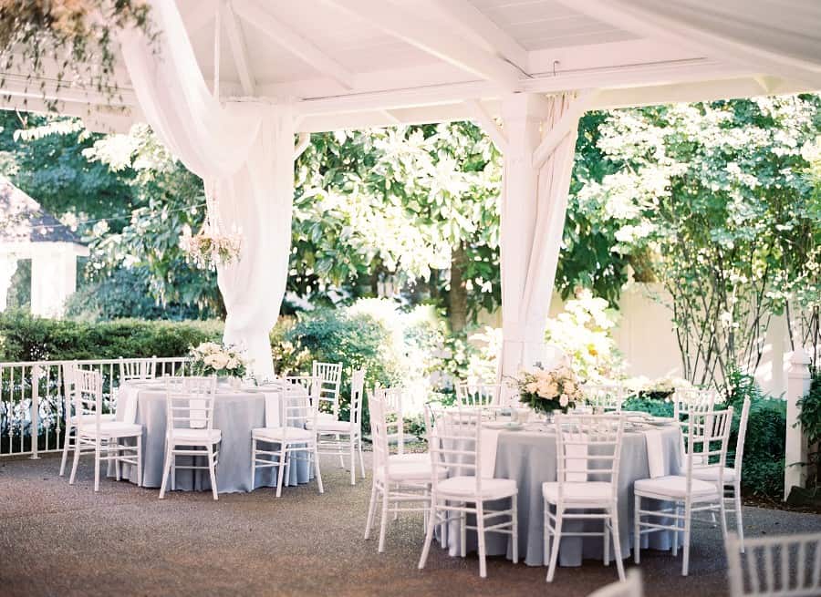 CJ's Off the Square | blue grey and white wedding reception with flowers in outdoor pavilion