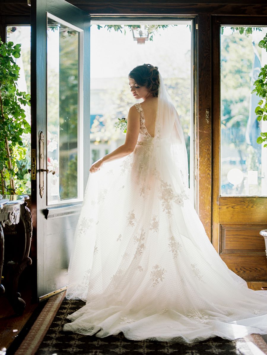 Bride posing to show lace detailing on the back of her wedding gown / Vintage / Fall / October / Merlot / Champagne