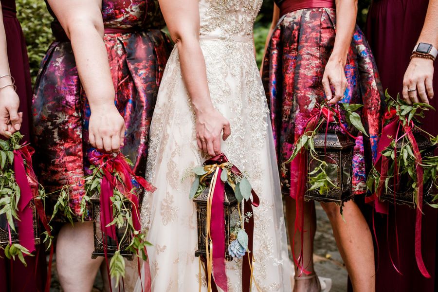 Close up of bridal party with lanterns instead of bouquets / relaxed garden / fall / September / burgundy / navy