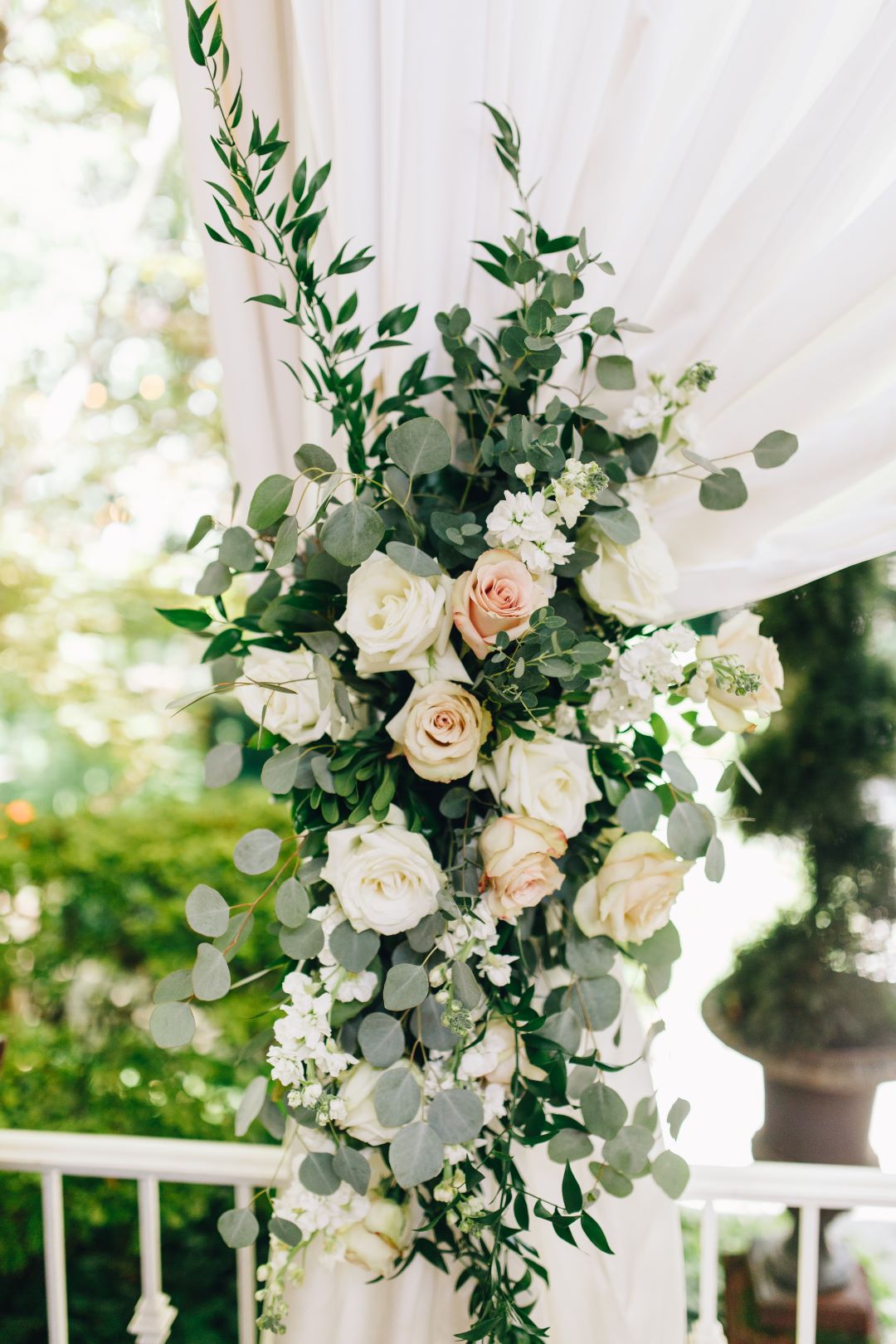blush and cream roses with eucalyptus and other greenery at earthy summer garden wedding in September, neutrals