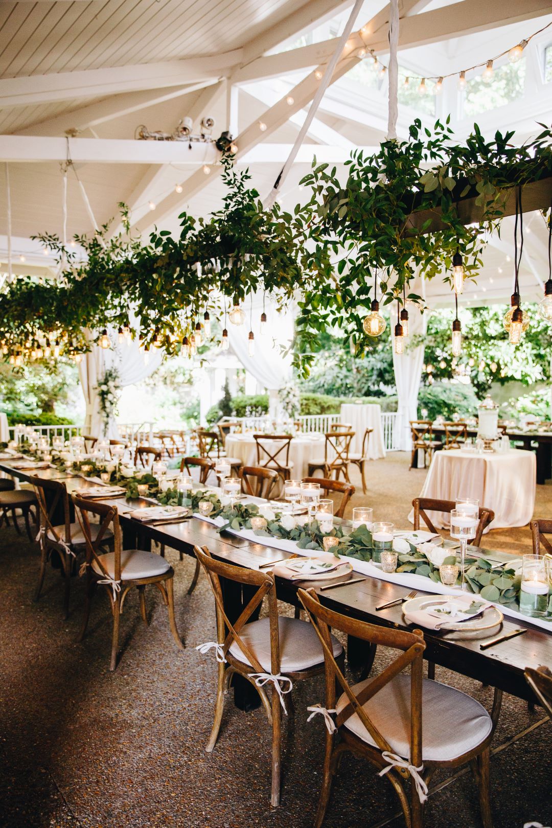 Long farmhouse table with greenery chandelier at earthy summer garden wedding in September, neutrals & greenery