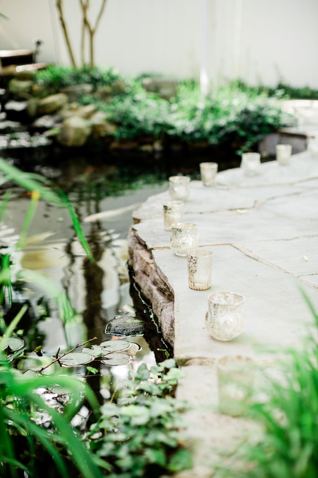 CJ's Off The Square | Tealight candles lining the pond of the garden