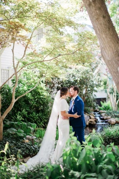 bride and groom kissing in garden at CJ's Off the Square