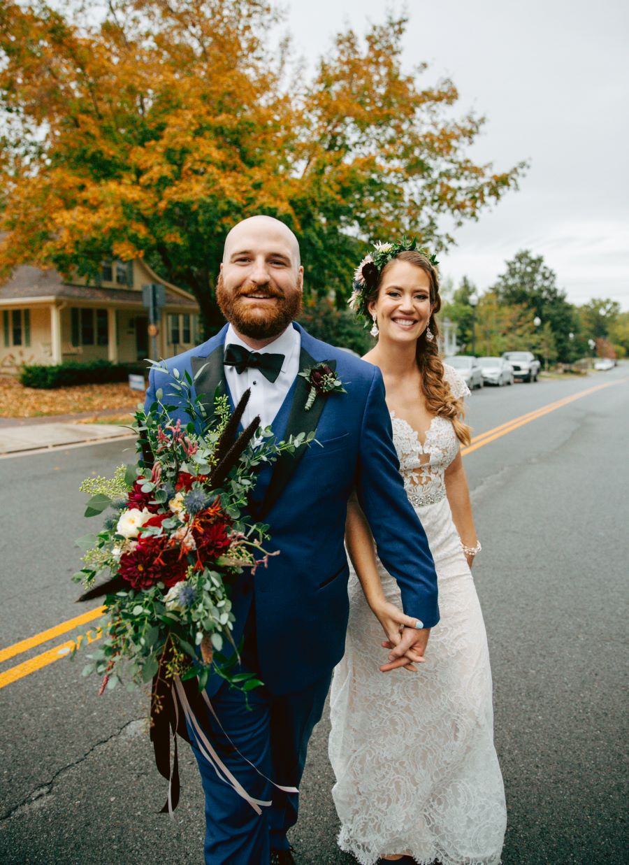 Bride and groom walking in the street holding hands / earthy / fall / October / burgundy