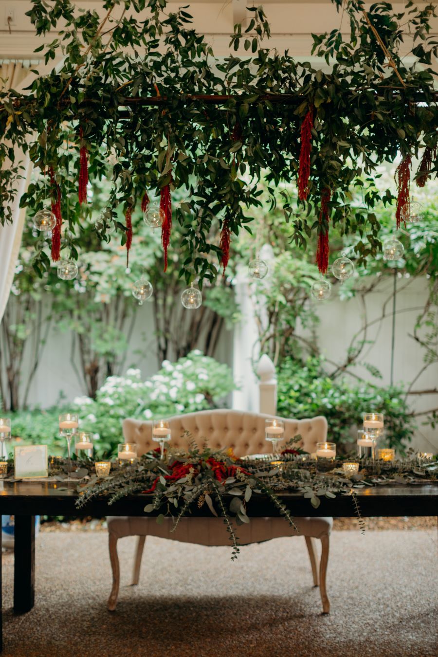 Tufted bench at head table with greenery overhead and fall foliage centerpieces / earthy / fall / October / burgundy