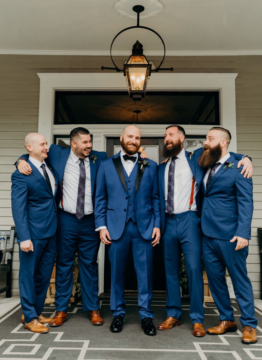 Groomsmen laughing and smiling on porch of wedding venue / earthy / fall / October / burgundy