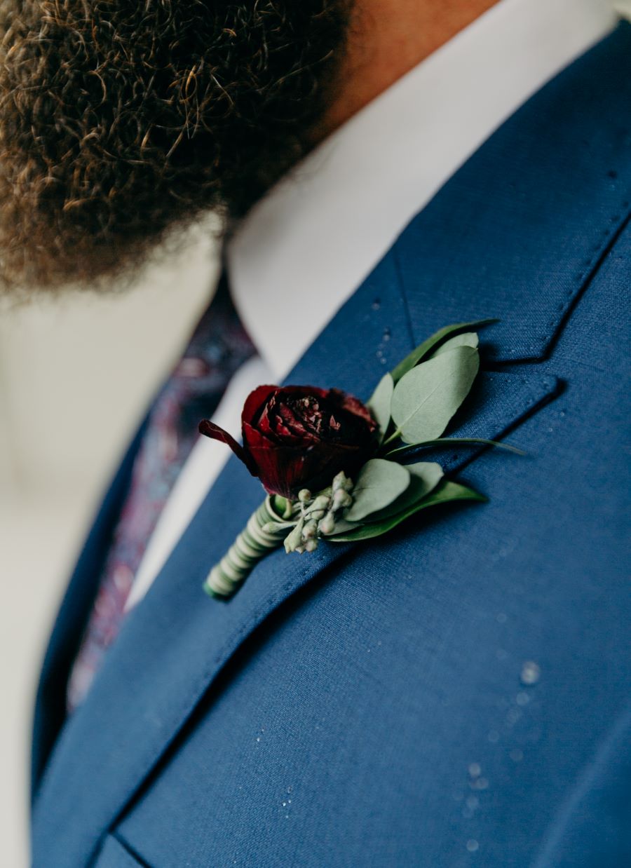 Close up of groom's boutonniere pinned to his tux / earthy / fall / October / burgundy