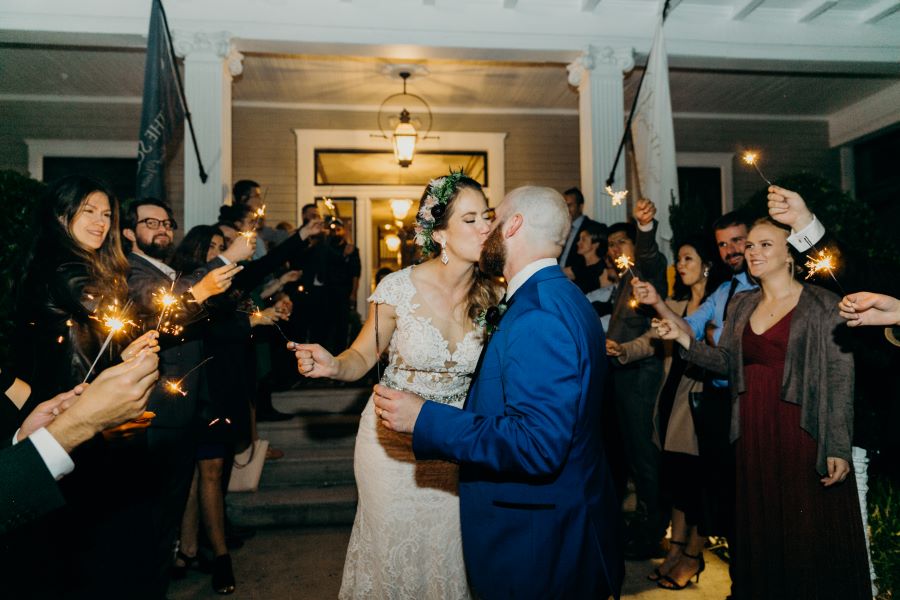Bride and groom kissing while holding sparklers at their send off / earthy / fall / October / burgundy