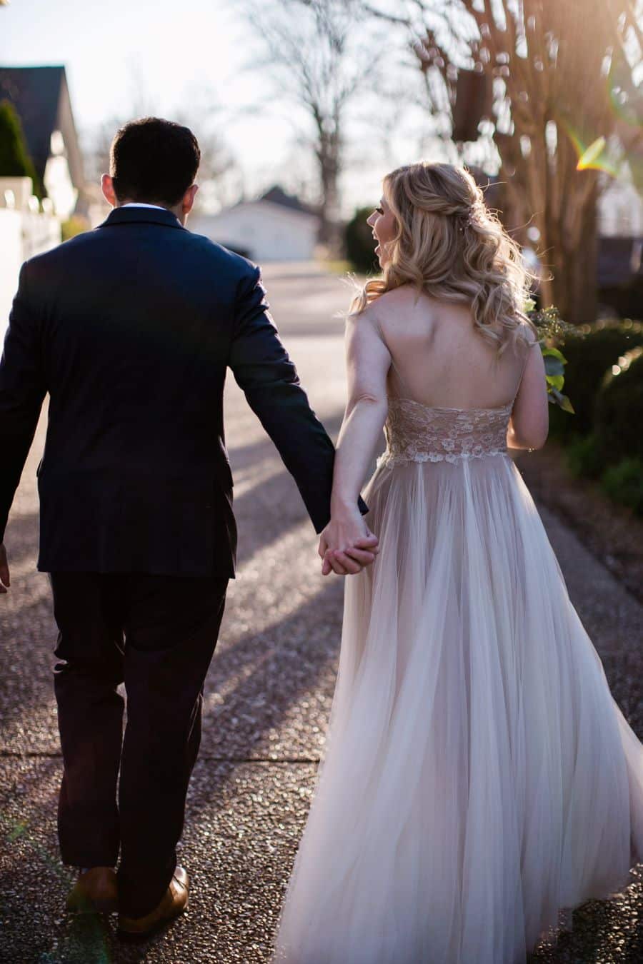 Bride and groom laughing and walking away while holding hands / Elopement / Spring / March / Dusty Rose
