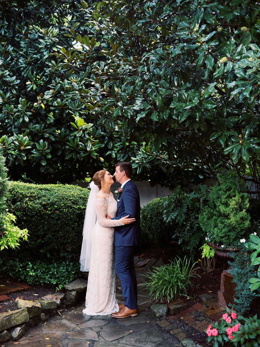 Bride and groom kissing under trees in the garden / Elopement / Summer / August