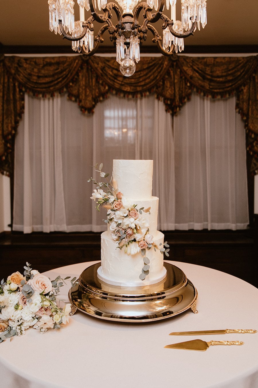 * Simple but elegant wedding cake with buttercream icing and fresh flowers and greenery at garden wedding venue CJ’s Off the Square near Nashville, TN. 