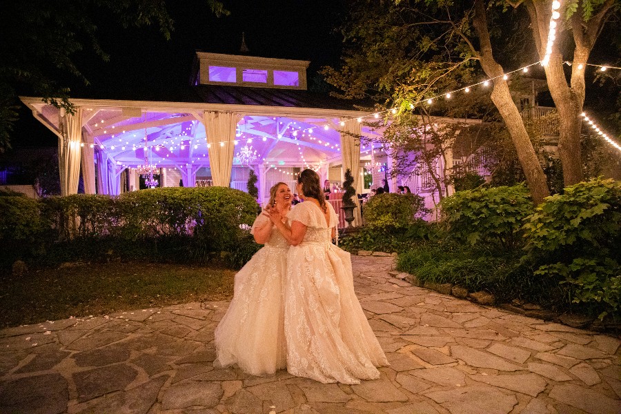 Two brides dancing together in garden of Nashville wedding venue
