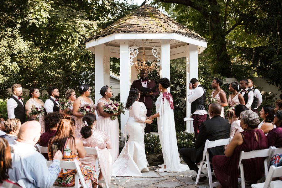 Brides and bridal party standing at the altar during garden ceremony / romantic lgbtq / fall / September / blush / burgundy