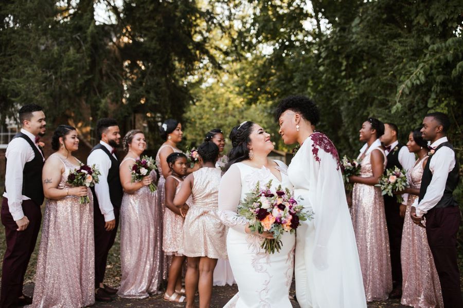Brides about to kiss in front of the wedding party / romantic lgbtq / fall / September / blush / burgundy