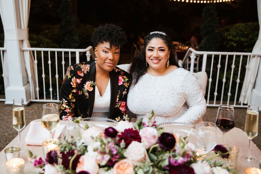 Brides after outfit change sitting at the sweetheart table / romantic lgbtq / fall / September / blush / burgundy