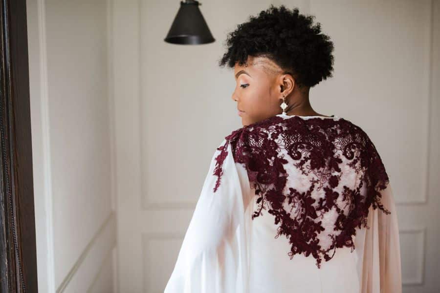 Bride wearing cape with burgundy lace accents on the back / romantic lgbtq / fall / September / blush / burgundy