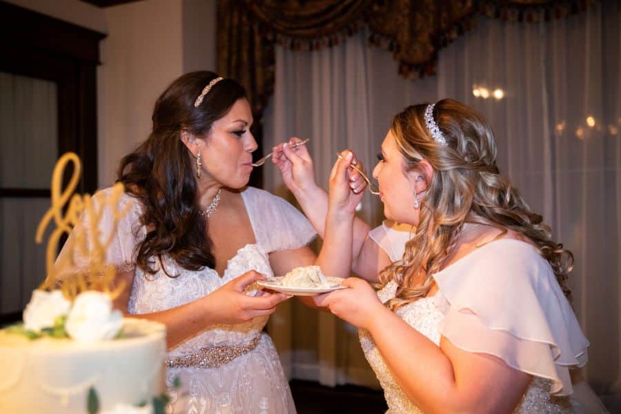 Newlywed brides feeding each other love is love cake at garden wedding reception / Romantic / Summer / September / Pink / Dusty Rose / Cream
