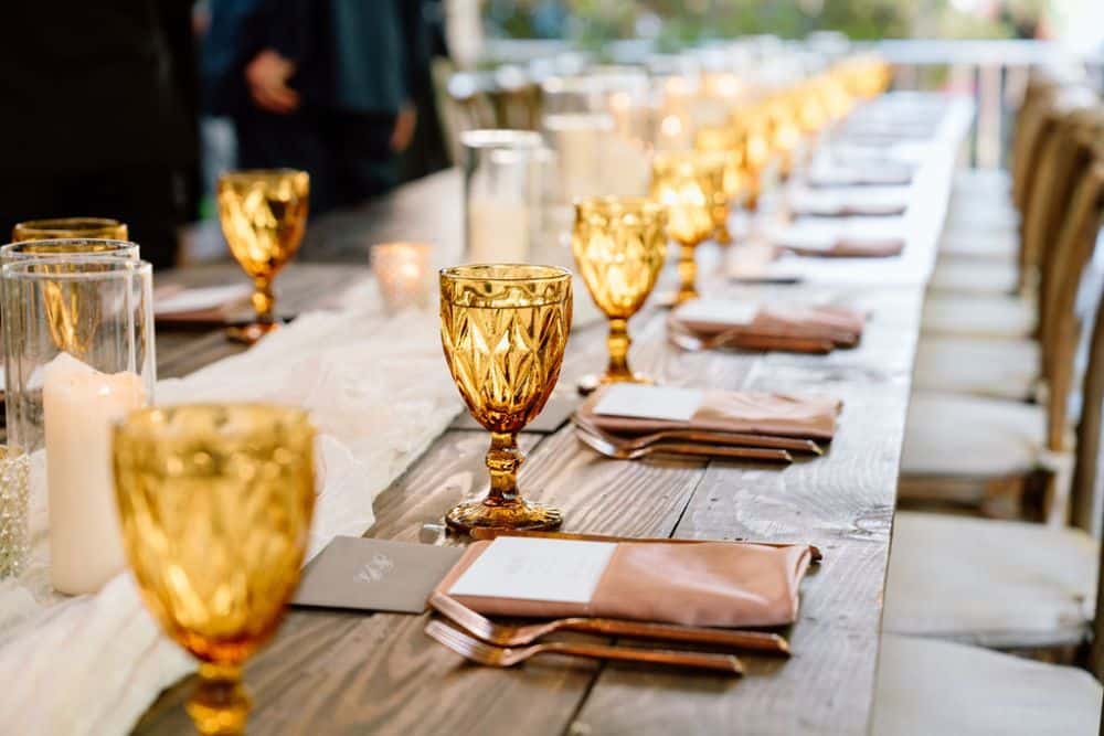 amber goblet with tawny satin napkin on farm table wedding reception | CJ's Off the Square wedding venue Franklin, TN