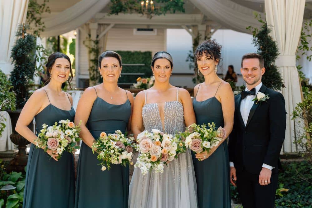 bride in silver beaded dress with bridesmaids in dark green dresses | CJ's Off the Square wedding venue Franklin, TN