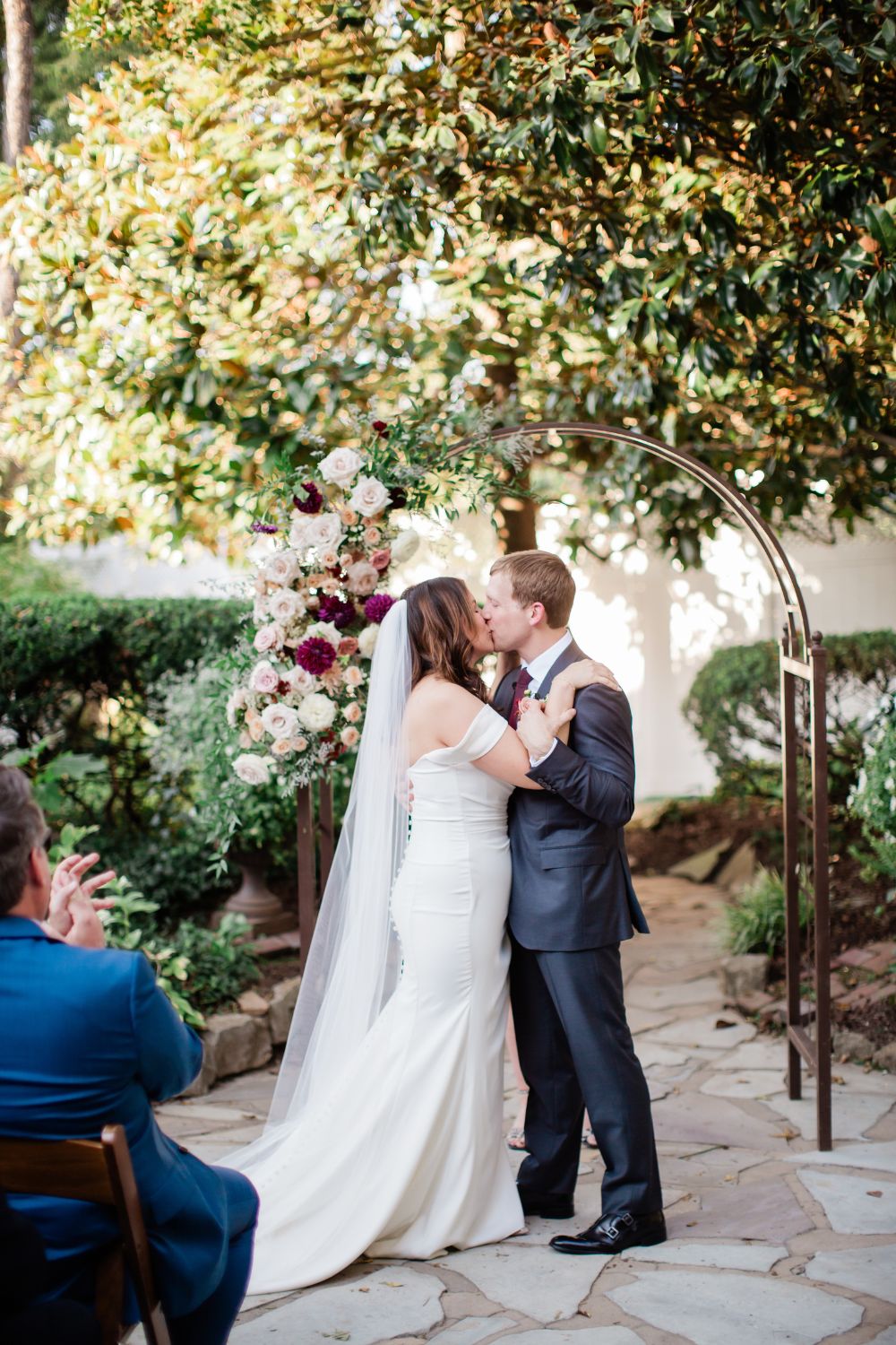 bride and groom share first kiss following their outdoor garden summer wedding at cjs off the square near Nashville