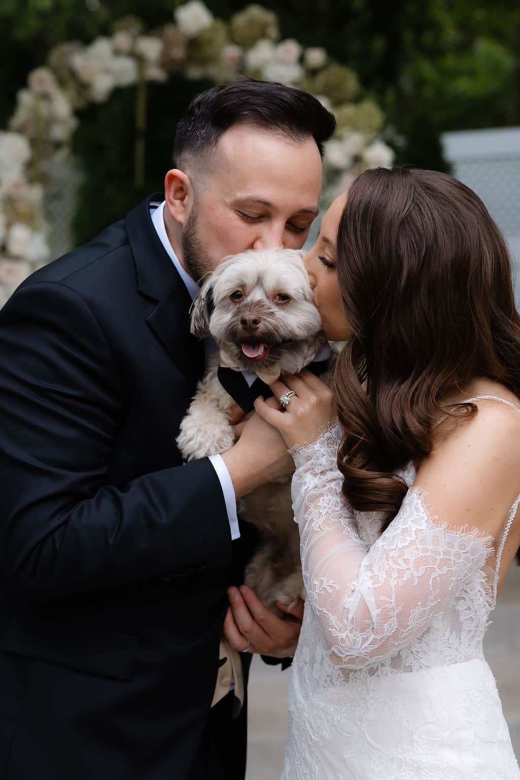 bride and groom kiss their dog