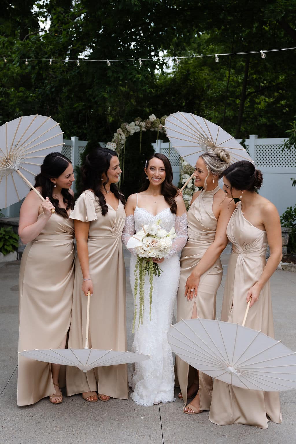 bride and bridesmaids pose with parasols