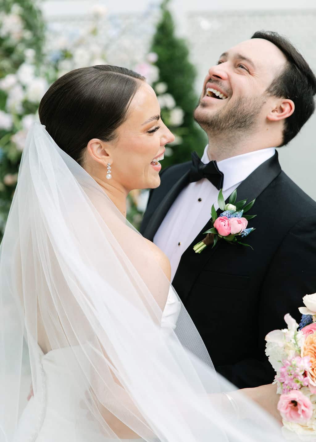 bride and groom smile in garden