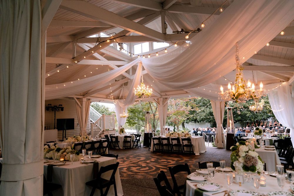 Elegant pavilion reception with romantic draping and sparkling chandeliers