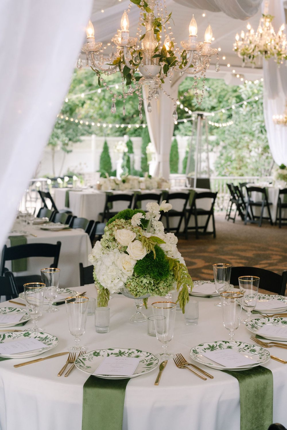 White floral reception centerpiece and candles in the wedding pavilion