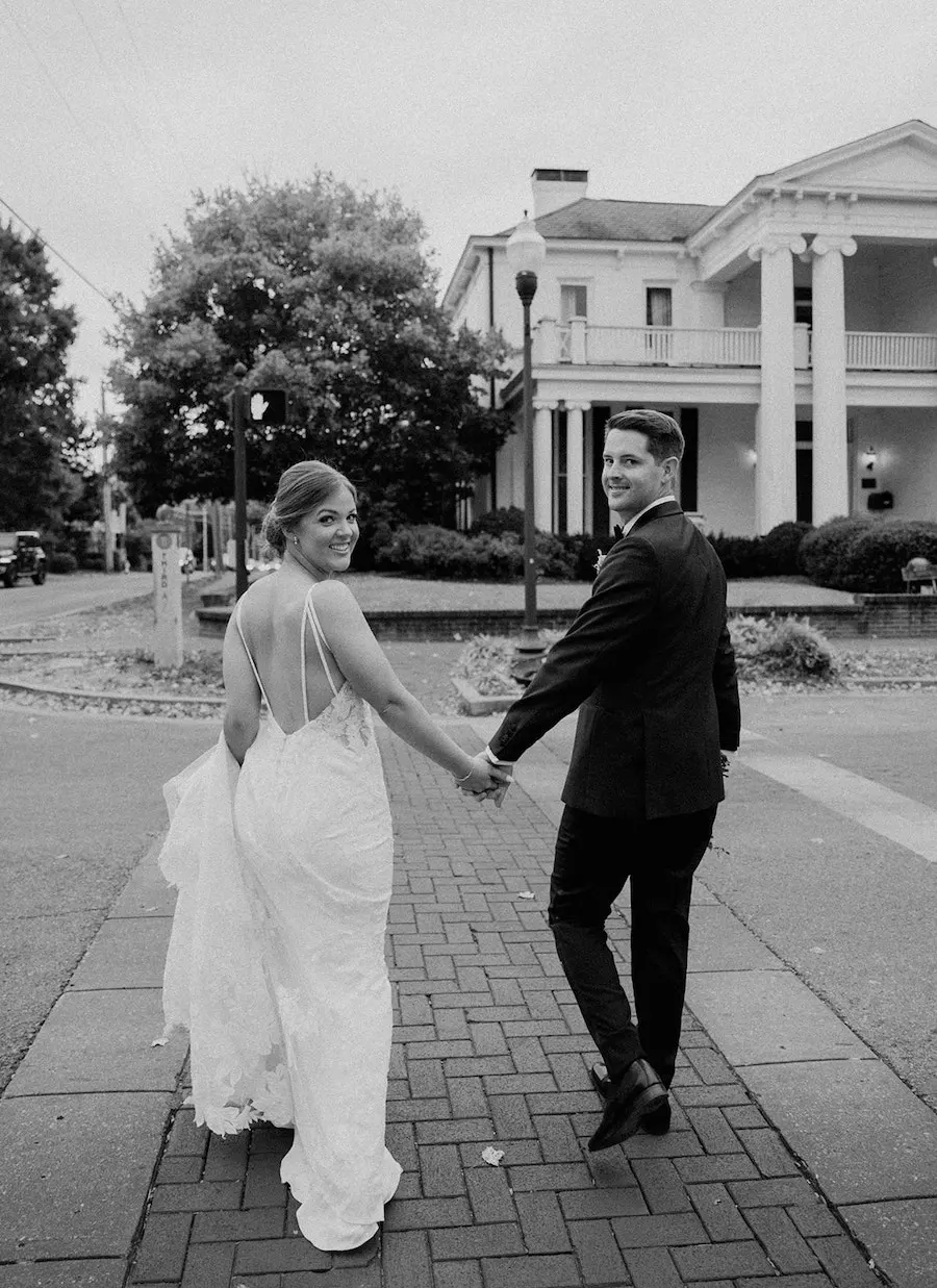 * Bride and groom walking through a romantic garden for their wedding ceremony at outdoor wedding venue CJ’s Off the Square (Franklin, TN). 